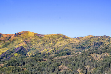 Fototapeta premium Majestic mountain range against a clear sky in autumn, portraying a sense of grandeur and serenity, showcasing natural beauty and inviting viewers to appreciate nature's wonders and peace