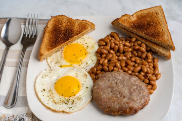 fried eggs  with sausage patty ,baked beansand toast