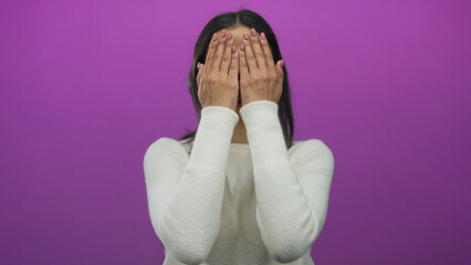 Woman in white sweater smiles with surprise over a vibrant pink background, revealing her cheerful expression.