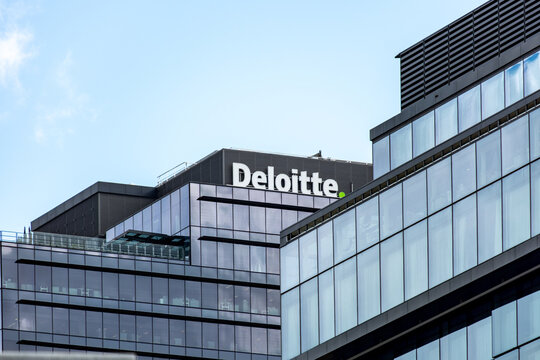 Deloitte signage on modern glass office building in Melbourne, Australia. Deloitte provides audit, consulting, financial advisory, risk advisory, tax, and legal services
