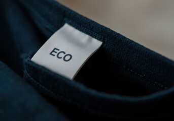 A close-up view of a clothing label showcasing the word "ECO" emphasizing sustainable fashion practices with a focus on eco-friendly materials