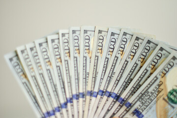 one hundred US dollar bills like a fan