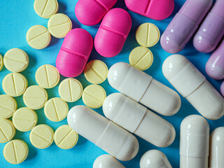 Capsules pill in pill amber glass bottle on blue background. Top view and close up