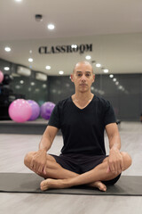 Fototapeta premium Hispanic bald man athlete in gym classroom doing yoga meditation while sitting