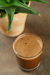 Beautiful Healthy Adaptogenic Drink in Glass, Trendy Vegan Elixir in Kraft Packaging on Rustic Table, Cozy Lifestyle Shot