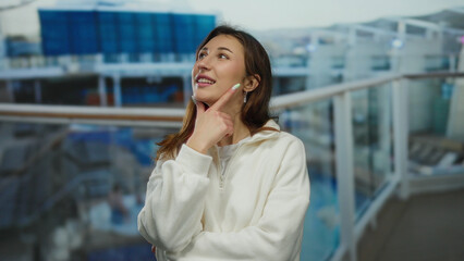Woman smiling on a cruise ship with thoughtful pose, enjoying the outdoor setting on a bright day...