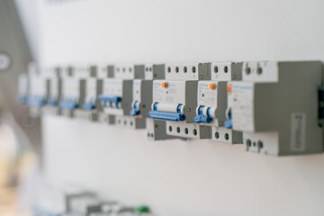 Row of electrical circuit breakers in distribution board showing power control safety switch system...