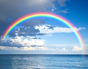 Vibrant rainbow arching over a calm ocean, under a partly cloudy sky