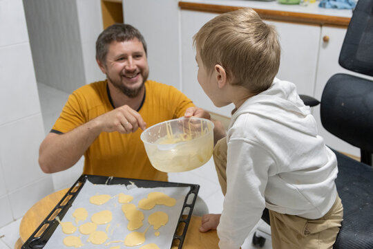 Father and son baking cookies together in the kitchen - Powered by Adobe