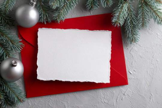 Christmas greeting card mockup with red envelope and silver ornaments
