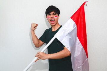 Excited young Asian men celebrate Indonesian independence day on 17 August by holding the...