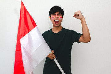 Excited young Asian men celebrate Indonesian independence day on 17 August by holding the...