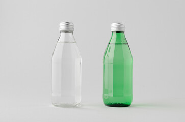 Clear and green glass water bottle mockup on neutral background