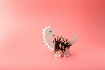 Eco dinosaur figure from natural pinecone and cardboard. Creative autumn project for kids,...
