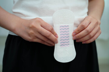 Asian woman holding sanitary napkin pad for hygiene menstrual period cycle protection. © Pakawadee
