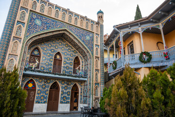 Obraz premium Elaborate tilework adorns a building's exterior. The Orbeliani Baths, finished in the 19th century, show Persian influence in sulfur bath construction. Balcony with holiday reindeers, arch windows.