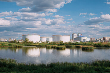 Naklejka premium Flowing water and sludge at an industrial water treatment plant near a bustling city under a summer sky