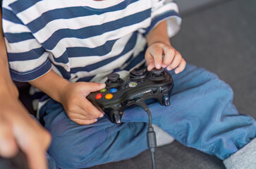 Gaming Fun. Child holding a video game controller, engaged in play.