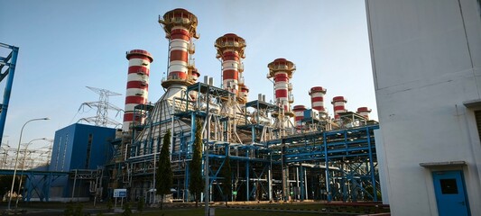 Industrial Power Plant: An imposing industrial power plant, featuring towering smokestacks and a complex network of pipes and structures, stands as a symbol of industry and progress. © dnixdony