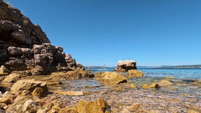 Naturist Woman Paddleboarding in Distance under Clear Blue Mediterranean Sky, Scenic Summer View of FKK Konobe Rocky Beach near Punat, Krk Island, Croatia Adriatic Sea, Coastal Cliffs, Islands