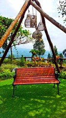 A Wooden bench in a cozy garden or serene park seating area with outdoor lighting decorated with...