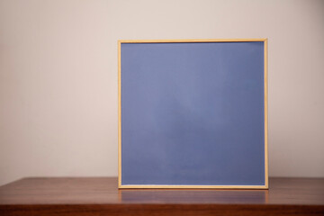 A painting on a bench on a wooden table. Frame concept. Memory concept. 
Space for text.
