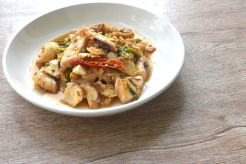 stir-fried spicy squid with salty egg and sauce on dish