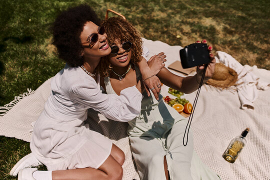 Summer picnic joy between best friends in the park with sunny smiles
