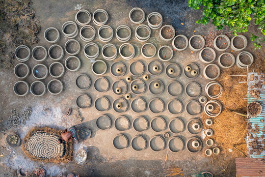 Bogura, Bangladesh - 22 October 2019: Aerial view of pottery arranged on the ground, creating a textured landscape of circles and earthy tones.