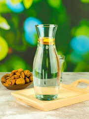 Artistic Photo of Mineral Water in Transparent Tumbler with Natural Light and Dreamy Green Background