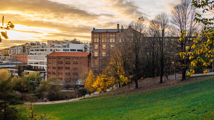 Charming Urban Park Setting at Sunset Featuring Historic Architecture and Lush Autumn Foliage in...