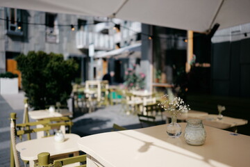 Charming Outdoor Café Setting with Elegant Decor and Natural Light in Modern Urban Surroundings