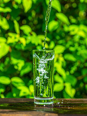 Dynamic Low-Angle Shot of Mineral Water Splashing in Glass Tumbler with Vibrant Green Background

