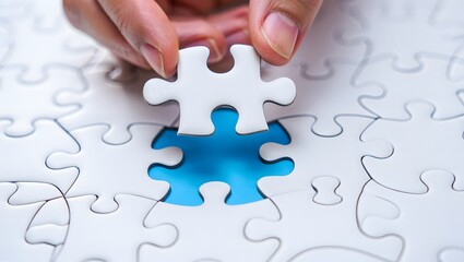 Hand placing the final white puzzle piece into a blue gap completing the picture