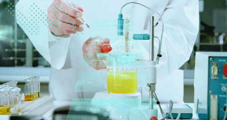 Scientist pipetting red solution from vial into beaker at bench, with micropipette, stirrer