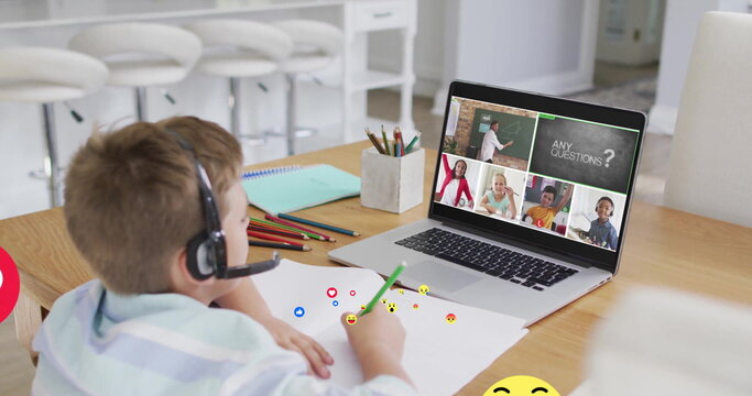 Writing boy wearing headset leaning in study, with laptop displaying virtual classroom and pencils