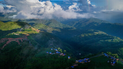 Lush green hills of Nepal blanketed in mist, showcasing the natural beauty and diverse landscape of the Himalayan foothills.