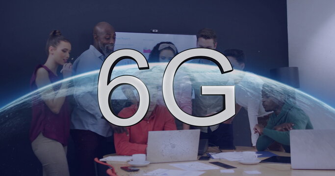 Collaborating team reviewing 6G presentation in modern meeting room with laptops and Earth overlay