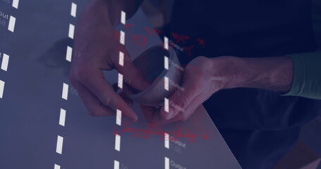 Holding smartphone in green-sleeved hands projecting coded text onto smooth tabletop at work desk