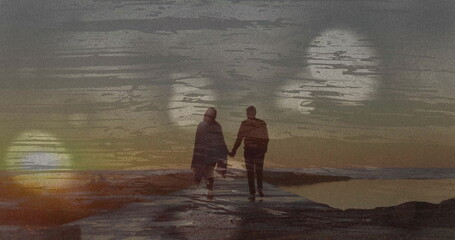 Walking couple holding hands on concrete pier into ocean at sunset, with water reflections, bokeh