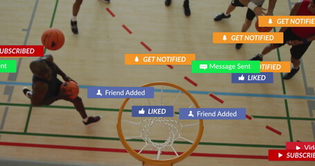 Dribbling male player moving toward hoop on gym court, with basketballs, notification graphics