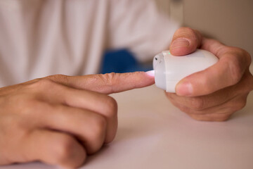 Close-up of an electric nail clipper in hand, modern personal care technology, highlighting compact...