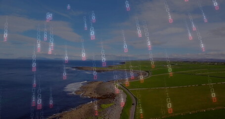 Displaying winding paved coastal road hugging shoreline above farmland, with binary code overlay