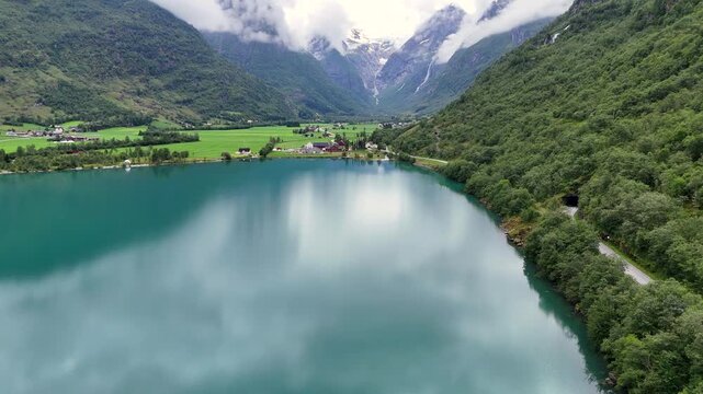Aerial view of calm Lake Oldevatnet surrounded by steep forested mountains in Oldedalen Valley