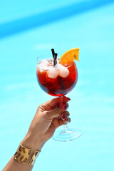 Female hand holding glass with red cocktail