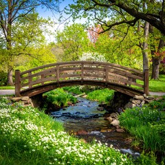 Wooden bridge over a stream in a park filled with flowers
