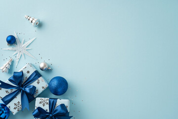 Festive Christmas arrangement featuring blue and silver decorations, wrapped gifts with bows, and...
