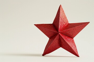 Obraz premium Red glitter star decoration on a plain background for festive celebrations
