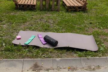 Outdoor workout equipment on yoga mat in garden setting
