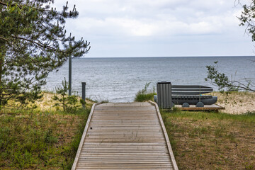 Wooden boardwalk and bench overlooking tranquil Baltic Sea